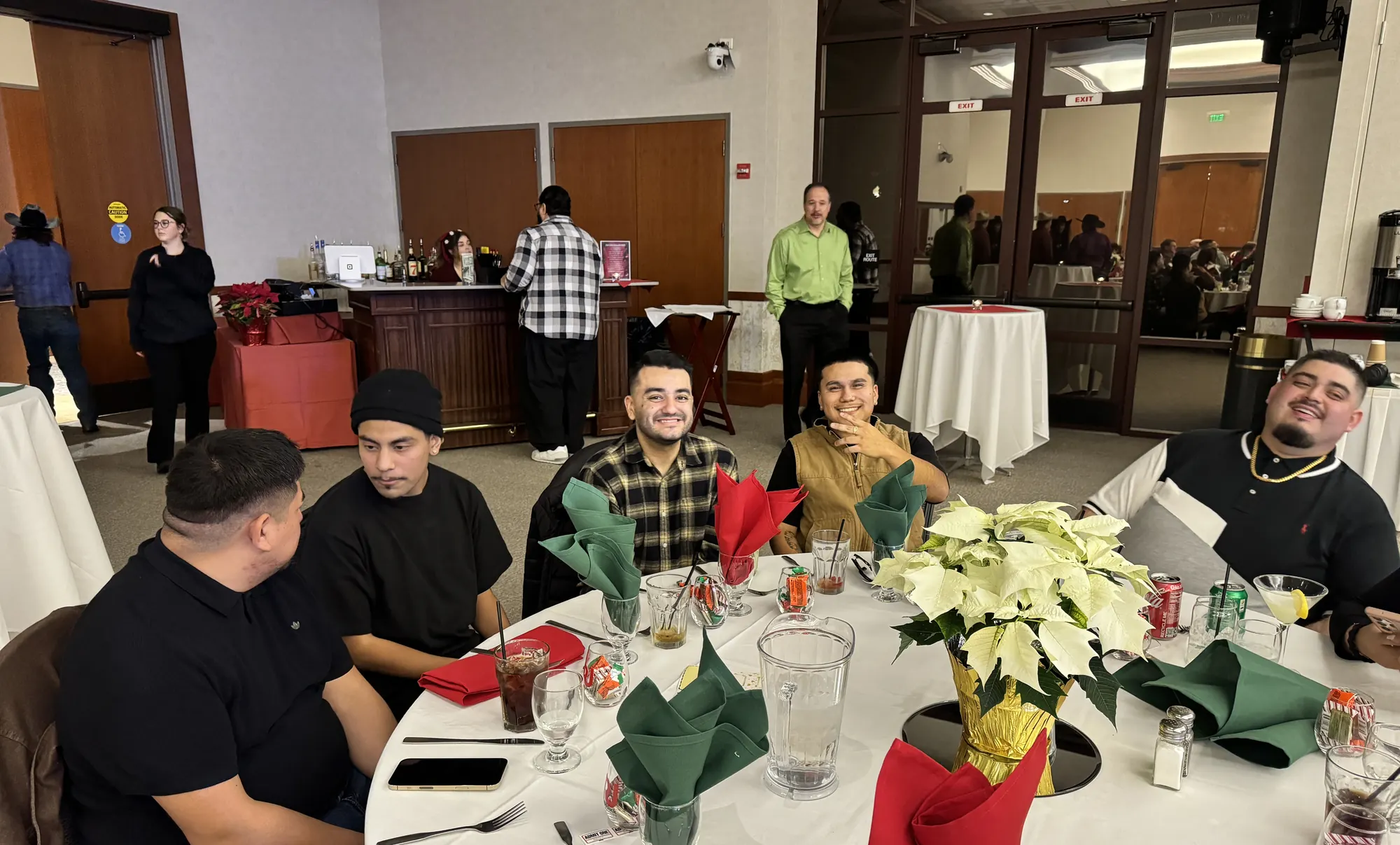 A table of younger RobbJack team members smiling at the company Christmas party.
